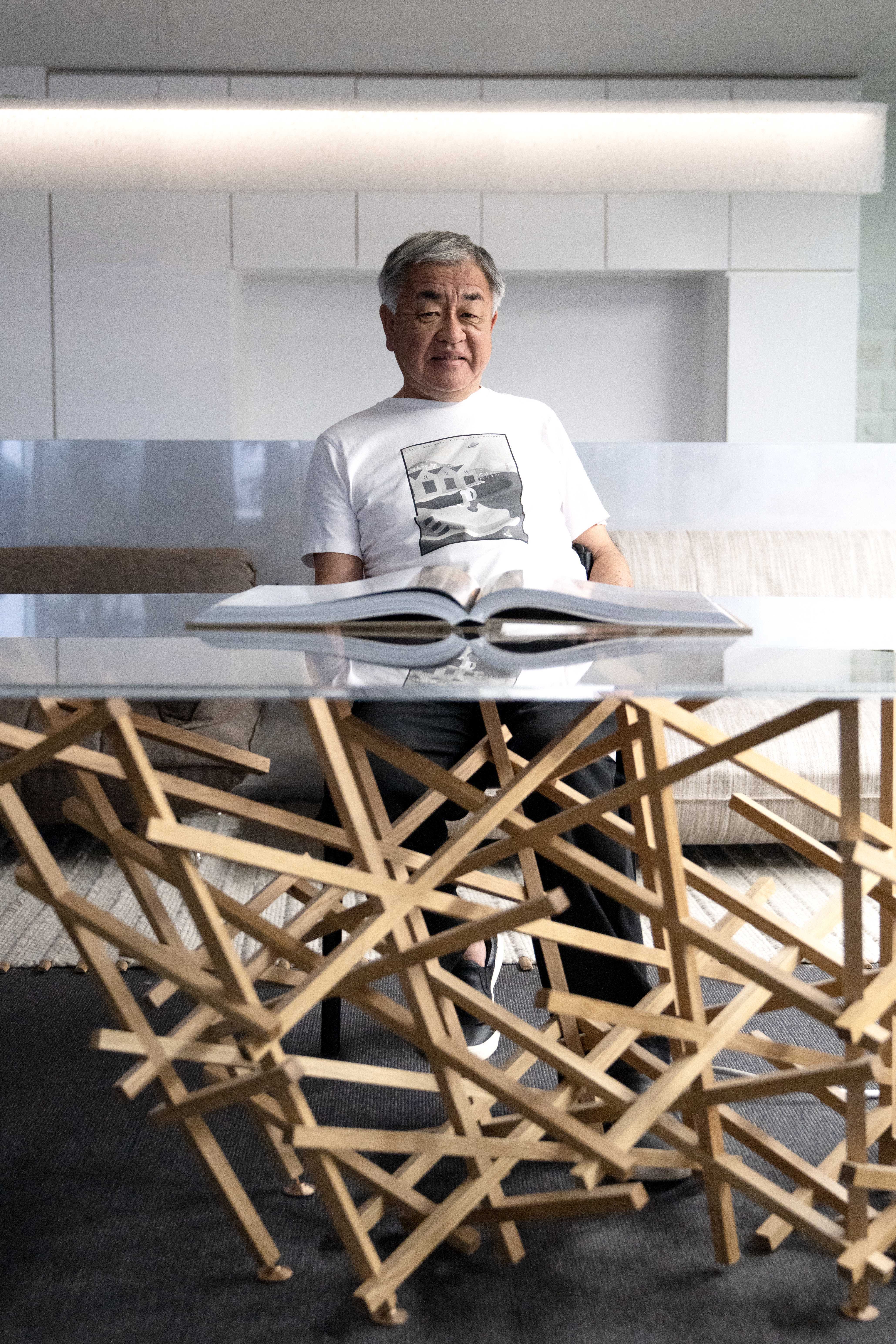 The architect Mr. Kengo Kuma sitting at his Kigumi table in his office in Tokyo